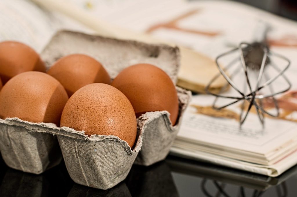 Alimento: Caixa com ovos em cima de uma mesa