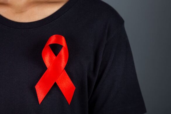 Tratamento HIV: pessoa com camiseta e laço vermelho sob o peito