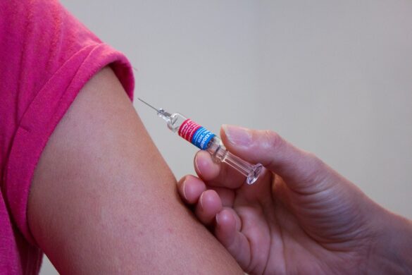 Prevenção do sarampo: Imagem de uma mão segurando uma seringa para aplicar uma vacina no braço de uma pessoa